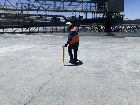 Operador utilizando un localizador electromagnético para seguir una red en una instalación industrial